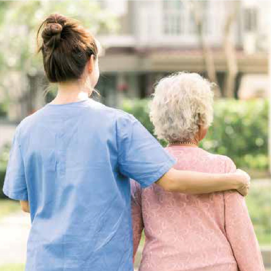Carer supporting an elderly woman outdoors, representing safe and secure key access for home care with the Keyguard Digital XL.